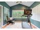 Bright workout room includes a treadmill, vaulted ceiling, and views of the backyard at 1905 Persimmon Grove Dr, Indianapolis, IN 46234