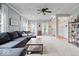 Spacious living room featuring a comfortable gray sofa, a ceiling fan, and ample natural light at 1905 Persimmon Grove Dr, Indianapolis, IN 46234