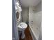 Classic bathroom features a pedestal sink, ornate mirror, new light fixture, and a white bathtub with shower at 1920 Kildare Ave, Indianapolis, IN 46218