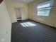 Bright bedroom with light paint, window, and gray carpet and a doorway leading to other areas of the home at 1920 Kildare Ave, Indianapolis, IN 46218