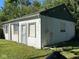 Side exterior view of a small building with siding of white cinder blocks and painted green boards on a sunny day at 1920 Kildare Ave, Indianapolis, IN 46218