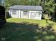 Exterior view of small, light yellow home with a green lawn and tree shadows across the grass at 1920 Kildare Ave, Indianapolis, IN 46218
