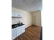 Updated kitchen features white cabinets, black countertops, wood floors and stainless steel sink at 1920 Kildare Ave, Indianapolis, IN 46218