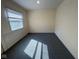 Room boasts a large window allowing natural light and neutral colored walls and carpet at 1920 Kildare Ave, Indianapolis, IN 46218