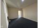 An empty room shows a white brick wall, gray carpet, and a white door leading to other rooms at 1920 Kildare Ave, Indianapolis, IN 46218