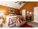 Comfortable bedroom featuring a ceiling fan, warm colored walls, unique decor, and accent chair at 2017 Rhettsbury St, Carmel, IN 46032
