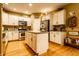 Well-equipped kitchen with an island, stainless steel appliances, ample cabinet space, and hardwood floors at 2017 Rhettsbury St, Carmel, IN 46032