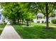 Beautiful neighborhood view with a sidewalk, manicured lawns, mature trees, and a charming community fountain at 2017 Rhettsbury St, Carmel, IN 46032