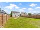 A large backyard features a lawn, a wooden deck, a white house and a fence, perfect for outdoor activities at 2111 S A St, Elwood, IN 46036