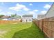 Fenced backyard features a wooden deck, lawn, and neighboring houses, creating a serene outdoor space at 2111 S A St, Elwood, IN 46036