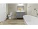Updated bathroom showcasing a gray vanity, toilet, and a modern bathtub with sleek fixtures at 2111 S A St, Elwood, IN 46036