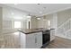 Bright kitchen features a large island with stove, white cabinetry, stainless steel appliances, and stylish pendant lighting at 2111 S A St, Elwood, IN 46036