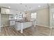 Bright, open-concept kitchen features a large island, white cabinetry, stainless steel appliances, and stylish pendant lighting at 2111 S A St, Elwood, IN 46036