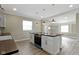 Bright kitchen features a large island with stove, white cabinetry, stainless steel appliances, and stylish pendant lighting at 2111 S A St, Elwood, IN 46036
