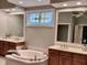 Bathroom with double sinks, a soaking tub and a stained glass window at 2223 Shaftesbury Rd, Carmel, IN 46032