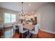 Bright dining area featuring a large table, hardwood floors, and access to the kitchen at 2223 Shaftesbury Rd, Carmel, IN 46032