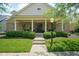 Charming brick home with manicured lawn, mature bushes, and inviting covered front porch at 2223 Shaftesbury Rd, Carmel, IN 46032