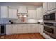 Bright kitchen featuring white cabinetry, stainless steel appliances, and hardwood flooring at 2223 Shaftesbury Rd, Carmel, IN 46032