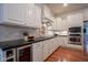 Well-lit kitchen features white cabinets, hardwood floors, and a stainless steel oven and microwave at 2223 Shaftesbury Rd, Carmel, IN 46032