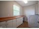 Functional laundry room with a built-in sink, generous counter space, and modern appliances at 2223 Shaftesbury Rd, Carmel, IN 46032