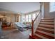 Bright living space with large windows, a sofa, and stairs leading to the second floor at 2223 Shaftesbury Rd, Carmel, IN 46032