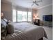 Bright main bedroom with bay window and chair, featuring a ceiling fan for optimal comfort at 2223 Shaftesbury Rd, Carmel, IN 46032