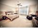 Spacious bedroom with a ceiling fan, soft decor, and a cozy reading area at 2223 Shaftesbury Rd, Carmel, IN 46032