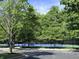 Community tennis courts offer a great recreational amenity for residents, surrounded by mature trees at 2223 Shaftesbury Rd, Carmel, IN 46032