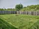 Large backyard with a well-maintained lawn, wooden fence, and fire pit, perfect for outdoor entertaining and relaxation at 2432 Bridlewood Dr, Franklin, IN 46131