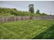 Large backyard featuring well-kept green grass, a fire pit, and tall wooden fencing at 2432 Bridlewood Dr, Franklin, IN 46131