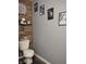 Toilet room with humorous wall art, wood plank accent wall, and wood-look flooring at 2432 Bridlewood Dr, Franklin, IN 46131