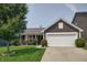 Inviting single-story home with manicured lawn, flowering bushes, and a two-car garage at 2432 Bridlewood Dr, Franklin, IN 46131