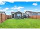 Backyard view features a well-maintained lawn, wooden fence, and gray siding on a sunny day at 2538 Bridlewood Dr, Franklin, IN 46131