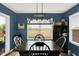 Dining room featuring a dark wooden table, dark walls, large window, and rustic light fixture at 2538 Bridlewood Dr, Franklin, IN 46131