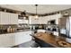 Well-lit kitchen featuring white cabinets, stainless steel appliances, dark countertops, and a wooden island at 2538 Bridlewood Dr, Franklin, IN 46131