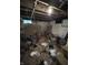 Unfinished basement with exposed ceiling and walls, concrete floor, and cluttered with items at 2627 Lincoln St, Anderson, IN 46016