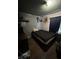 Bedroom with dark walls, a small bed, and hardwood floors plus some items stored on shelves at 2627 Lincoln St, Anderson, IN 46016