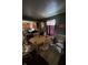 View of a dining room with a wooden table, chairs, and a window, with clutter and an adjoining space at 2627 Lincoln St, Anderson, IN 46016