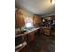 View of a kitchen with wood cabinets, a double sink, and cluttered countertops and floors at 2627 Lincoln St, Anderson, IN 46016