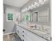 Bright bathroom boasts dual vanities with granite counters, updated fixtures, and a large mirror at 2871 Mullinix Rd, Greenwood, IN 46143