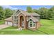 Elegant home with brick and gray siding, large arched window and three-car garage at 2871 Mullinix Rd, Greenwood, IN 46143
