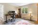 A cozy office room with desk, cabinets, and large window overlooking the yard at 2871 Mullinix Rd, Greenwood, IN 46143