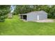 View of a blue outbuilding and shed on a verdant lawn at 2871 Mullinix Rd, Greenwood, IN 46143