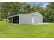 Metal outbuilding on a well-maintained green lawn, featuring open bay and sliding door access at 2871 Mullinix Rd, Greenwood, IN 46143