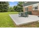 The backyard features a charming concrete patio with green table and chairs, ideal for outdoor dining at 2871 Mullinix Rd, Greenwood, IN 46143