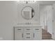 Clean white bathroom featuring a modern round mirror and contemporary white vanity at 2903 Winthrop Ave, Indianapolis, IN 46205