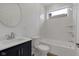 Bright bathroom featuring a shower-tub combination and navy vanity with storage at 2903 Winthrop Ave, Indianapolis, IN 46205