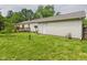 View of a spacious backyard with a wooden deck, lush green grass, and mature trees on a sunny day at 3004 N Timber Ln, Muncie, IN 47304