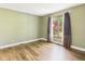 View of a bedroom featuring neutral paint, wood-look flooring, a bright window, and soft lighting at 3004 N Timber Ln, Muncie, IN 47304
