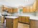View of the kitchen featuring light wood cabinets, laminate countertops, stainless dishwasher, and a kitchen island at 3004 N Timber Ln, Muncie, IN 47304